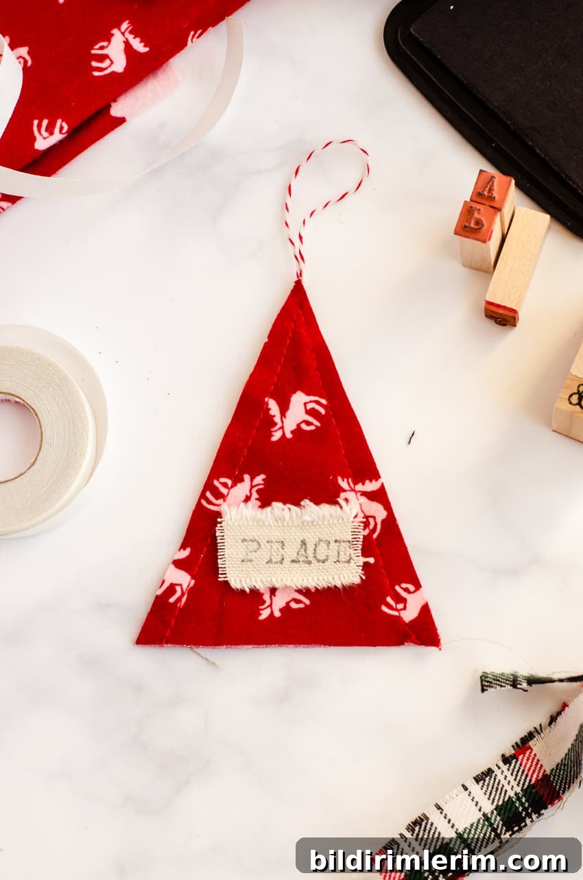 Stamp personalized words on the fabric message tag of these DIY Scandinavian inspired ornaments. This one says "Peace".