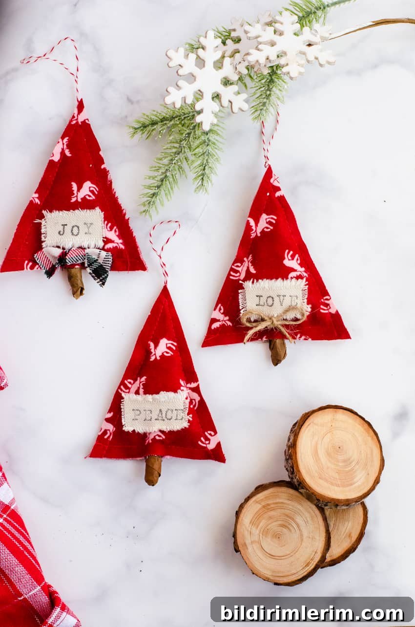 3 Red and White DIY Scandinavian Christmas ornaments made out of fabric and stamped with the words "joy, love, and peace".