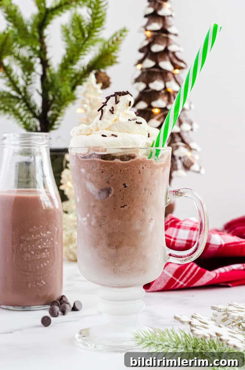 Clear mug with hot frozen chocolate in it with a green striped straw.