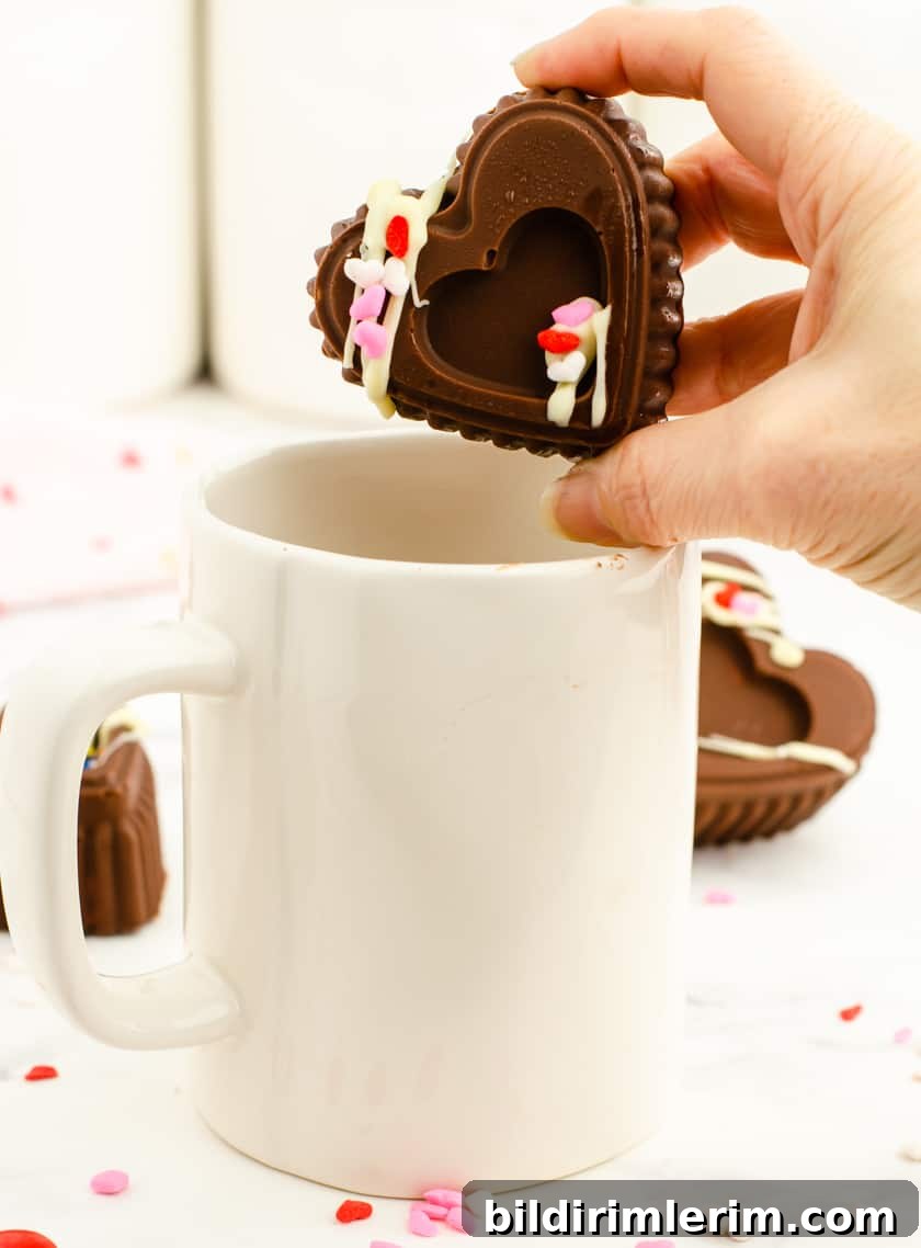 A valentine chocolate bomb being placed in a large mug