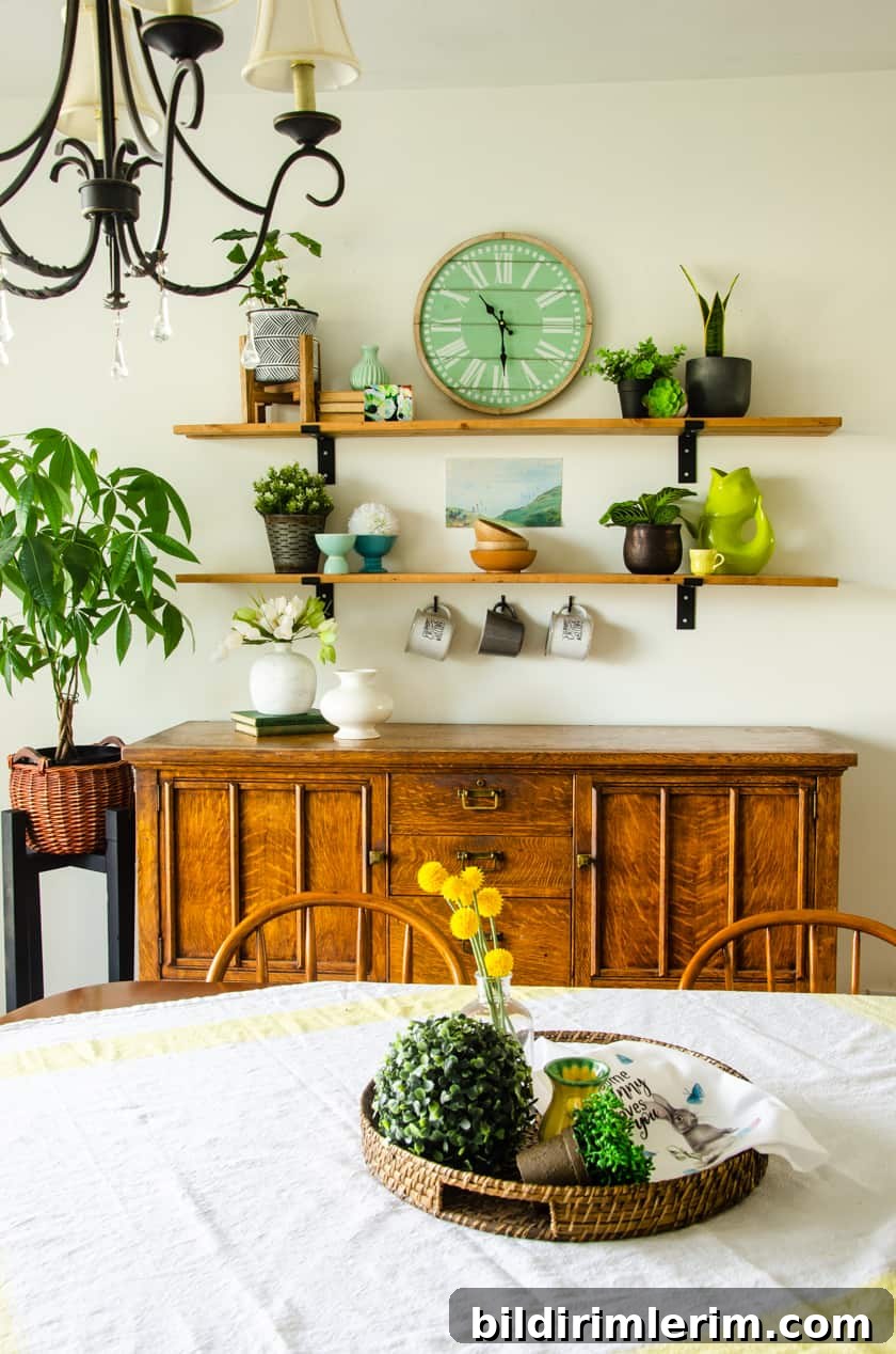 Antique oak dining room buffet with two farmhouse shelves above it with faux and real houseplants arranged on it.