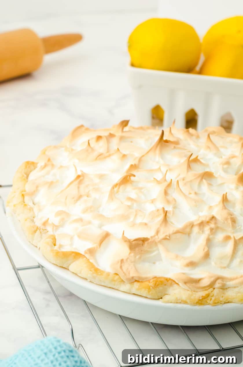 A lemon meringue pie cooling on a cooling rack.