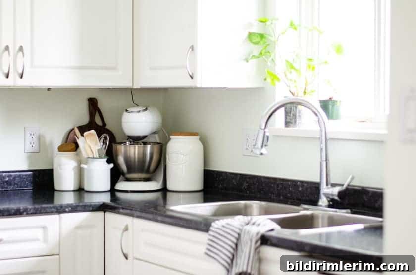 Budget-Friendly Small Kitchen Remodel Ideas 6 A mixer and canisters sitting on the counter of a small kitchen in the corner beside the sink.