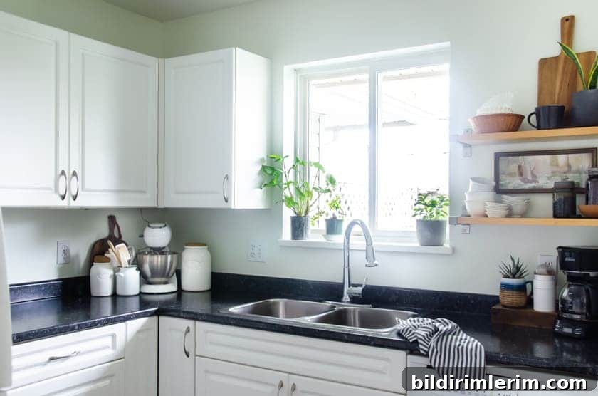 Budget-Friendly Small Kitchen Remodel Ideas 7 A small kitchen sink with window above and cupboards beside.