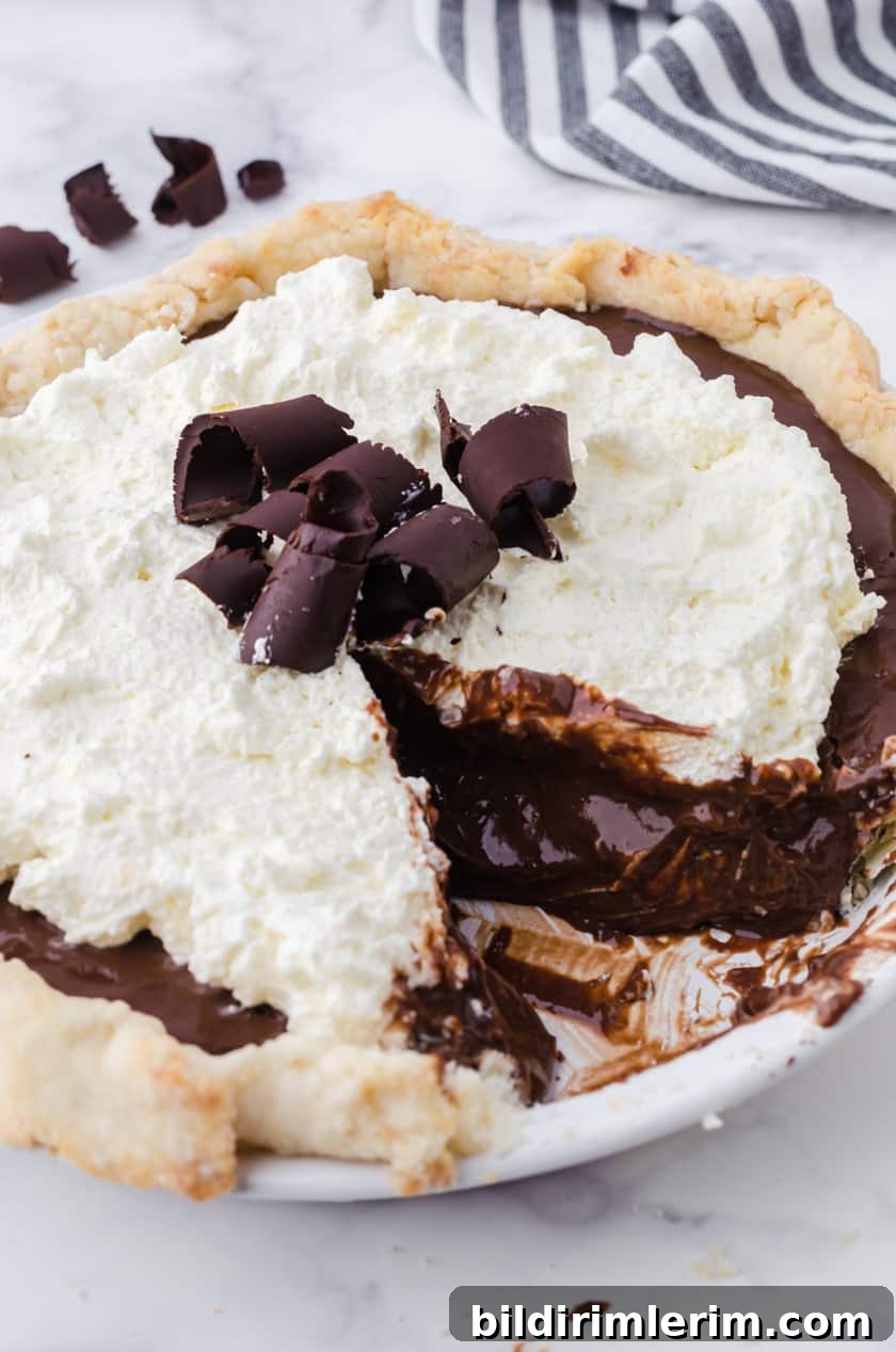 Chocolate pudding pie with a slice out of it.