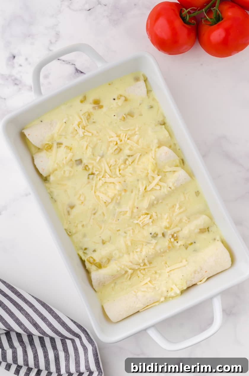 A pan of creamy chicken enchiladas assembled and ready to put in the oven.