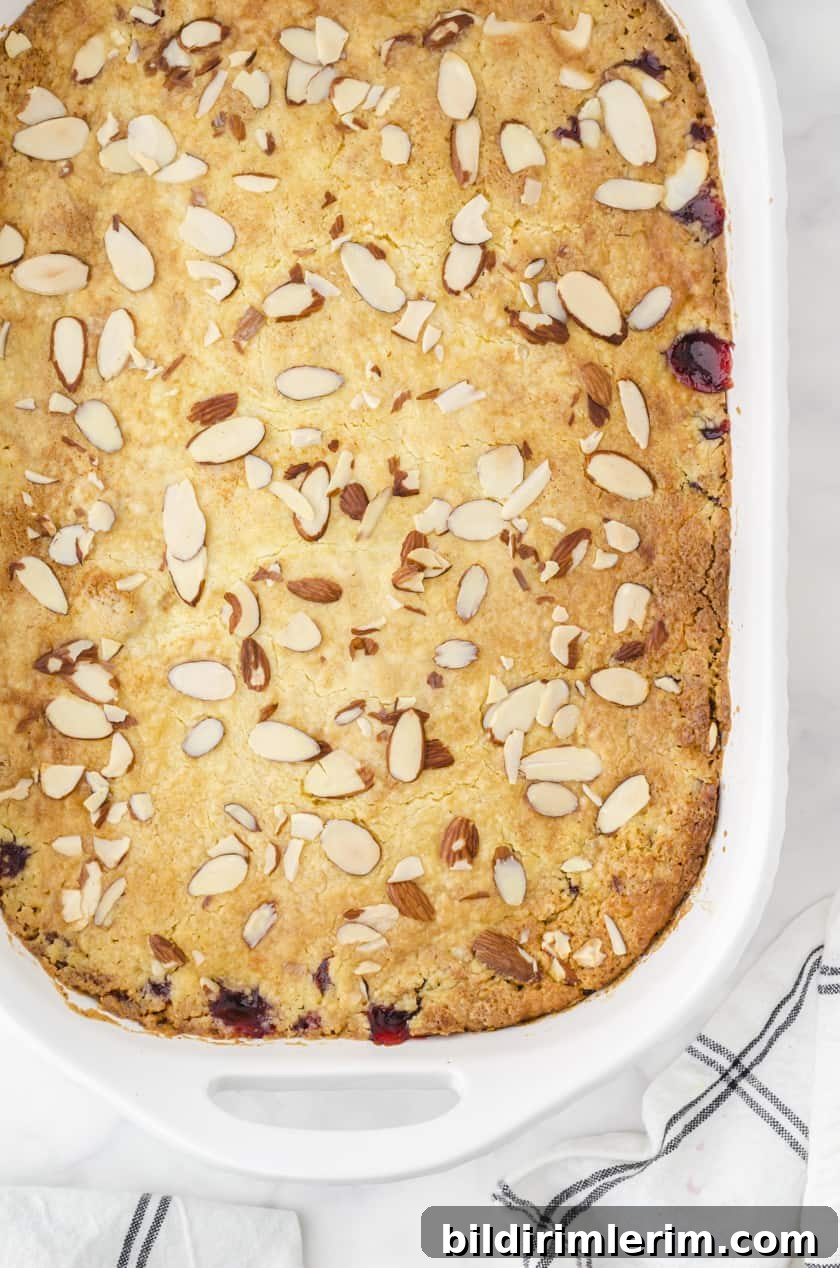 Baked cherry dump cake with sliced almonds on the top.