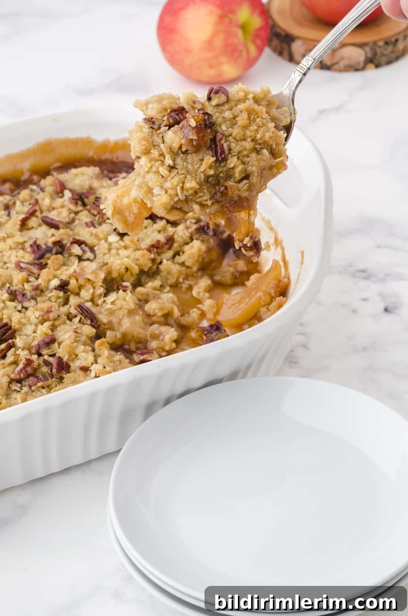 Large serving spoon dishing out apple crisp.