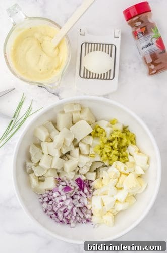 Classic potato salad with egg ingredients in a mixing bowl