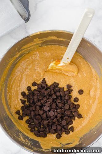 Moist Pumpkin Bread Made with Yellow Cake Mix 7 chocolate chips being stirred into pumpkin bread batter