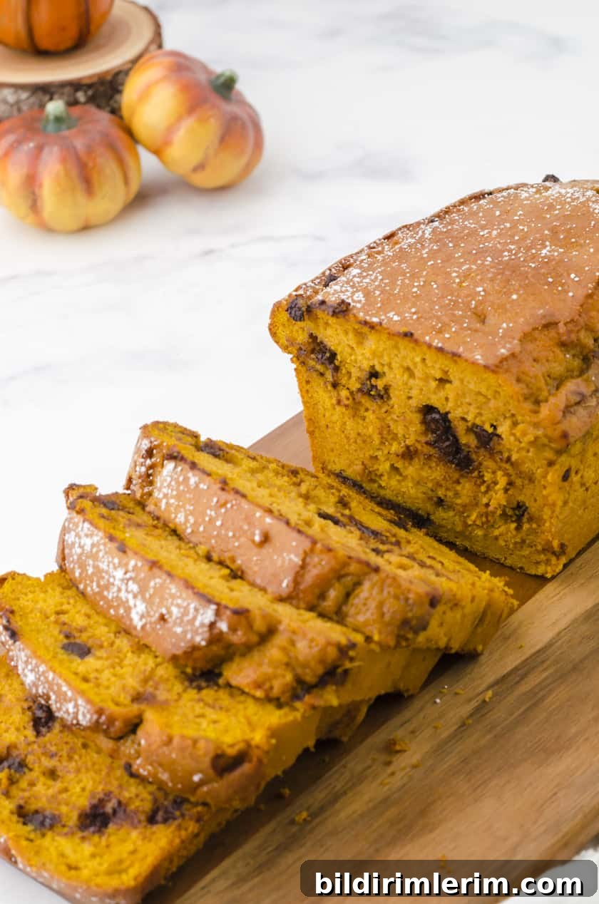 Moist Pumpkin Bread Made with Yellow Cake Mix 9 Close up of sliced chocolate chip pumpkin bread on a cutting board.