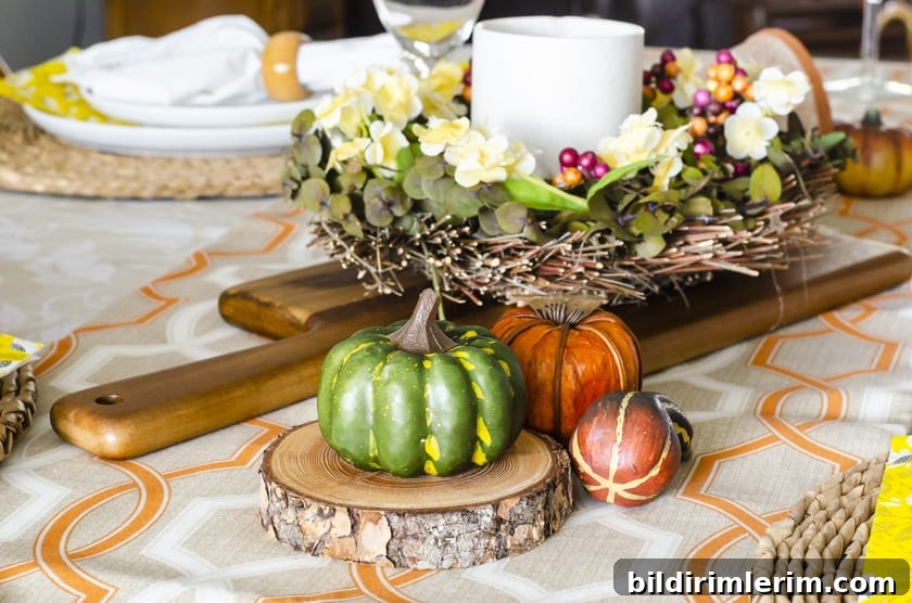 A Fall dining room table centerpiece with faux pumpkins beside