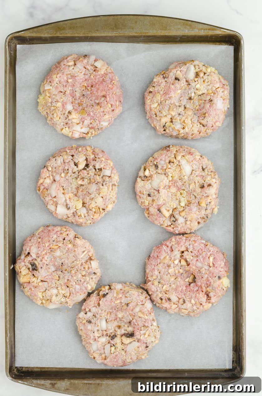 Homemade turkey burger patties on a parchment lined baking sheet