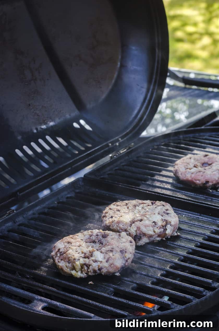 Turkey burgers cooking on a barbecue grill.