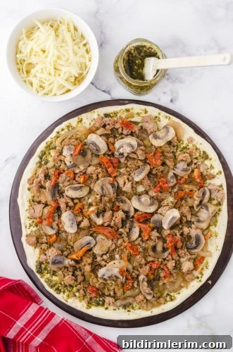 chopped sundried tomatoes layered on pesto pizza