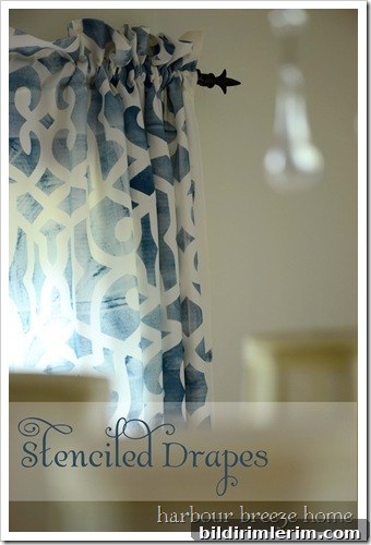 close up of blue stenciled curtains hanging on a black rod in a dining room
