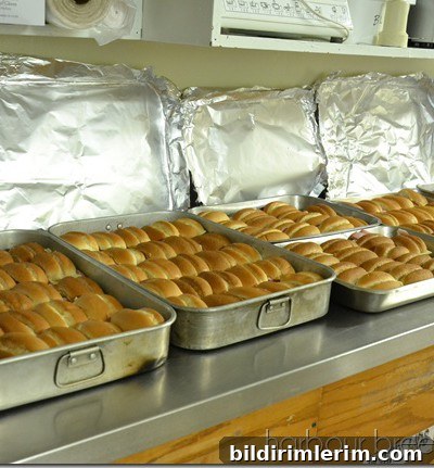Ham and Cheese Sliders Recipe for 65 Guests 8 pouring butter sauce over buns