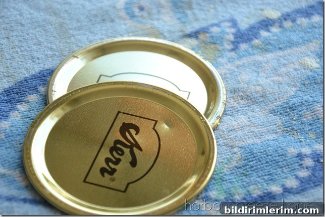 Painted mason jar lids in a dark blue color.