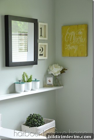 Bathroom vignette showing the finished painted jars on a shelf.