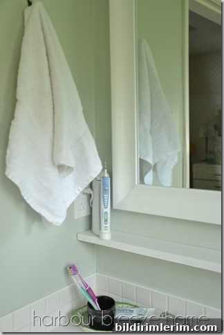 A bathroom hand towel hanging on a hook above the bathroom sink.