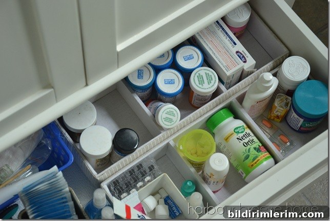 Bathroom vanity drawer organized with organization trays containing medicines and supplies.