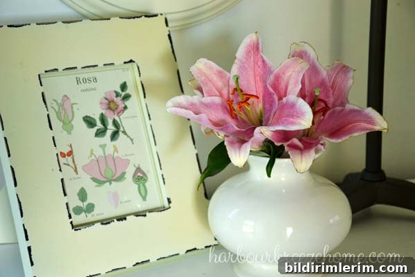DIY Flower Arrangements Using Grocery Store Blooms 7 Pink lillies in a white vase sitting beside a framed botanical print