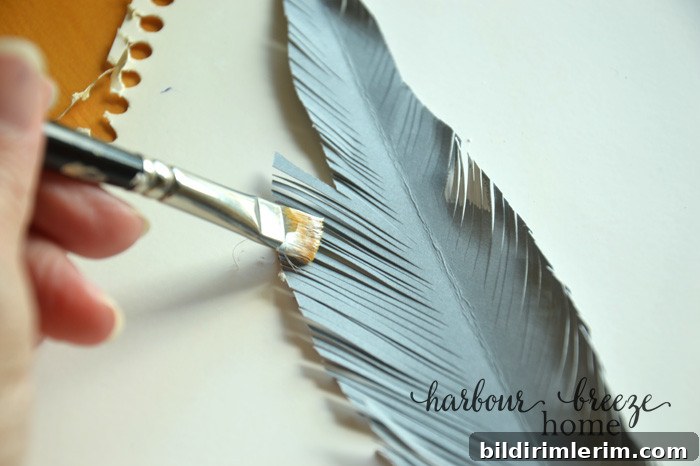 DIY Paper Feathers Tutorial: Handmade Feather Crafts 5 Painting the edges of a paper feather with white acrylic paint