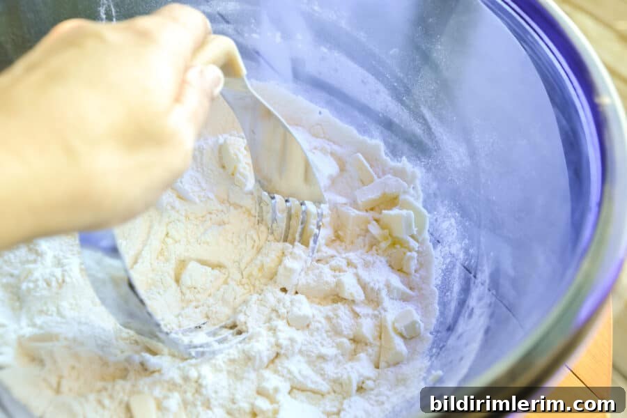 Butter being cut into the dry ingredients for this buttermilk cranberry scone recipe.