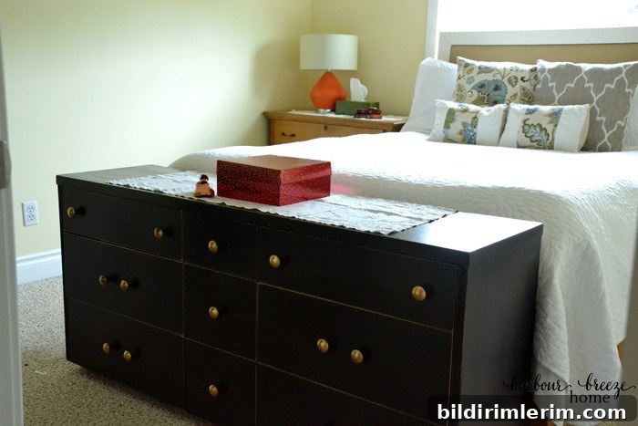 A long low dresser sits at the foot of the bed and provides much needed storage in a small bedroom.