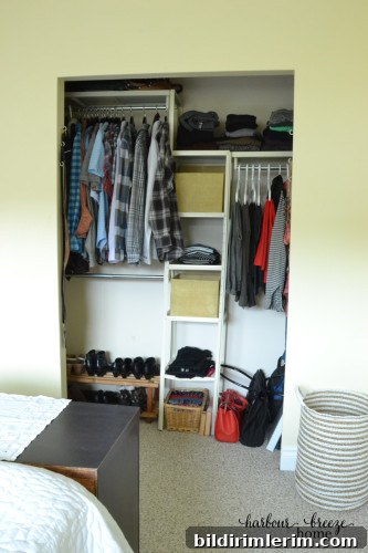 A Closet organizer with covered baskets and hanging racks organized nicely.