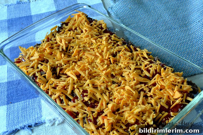 One-Pan Cheeseburger Casserole with Homemade Biscuit Topping 4 Grated cheddar cheese sprinkled as a layer in a cheeseburger casserole recipe.