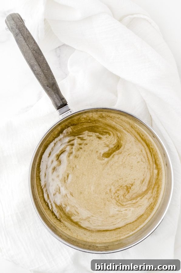Ingredients for the poke and pour cake sauce melted in a sauce pan.