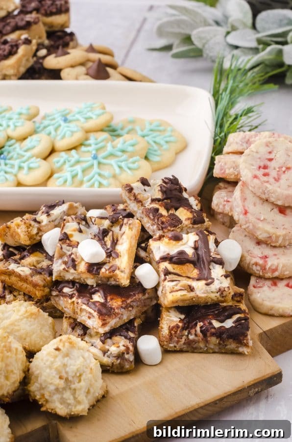 Christmas Cookie Charcuterie Board with Homemade Cookies 4 Smores magic cookie bars with marshmallows sprinkled on it as part of an arrangement on a Christmas charcuterie board.