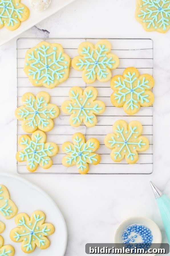 Snowflake sugar cookies on a wire cooling rack.