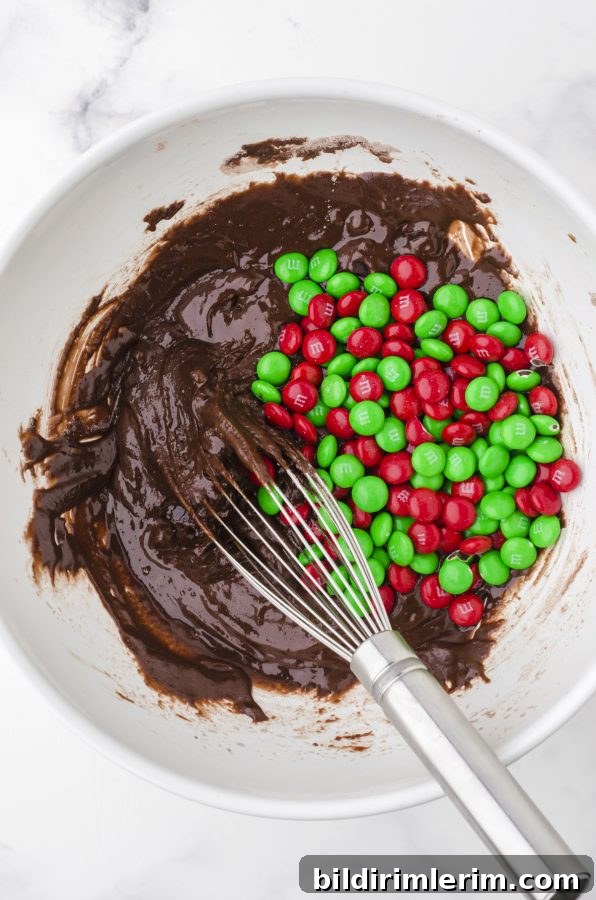 Brownie mix cookie ingredients being stirred together in a large mixing bowl.