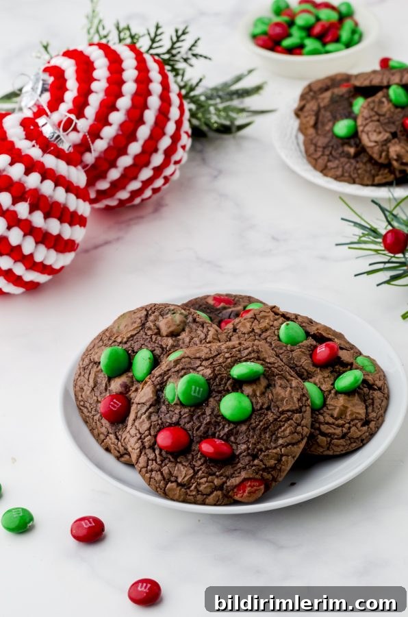 A small plate of brownie mix cookies with red and green M&Ms.