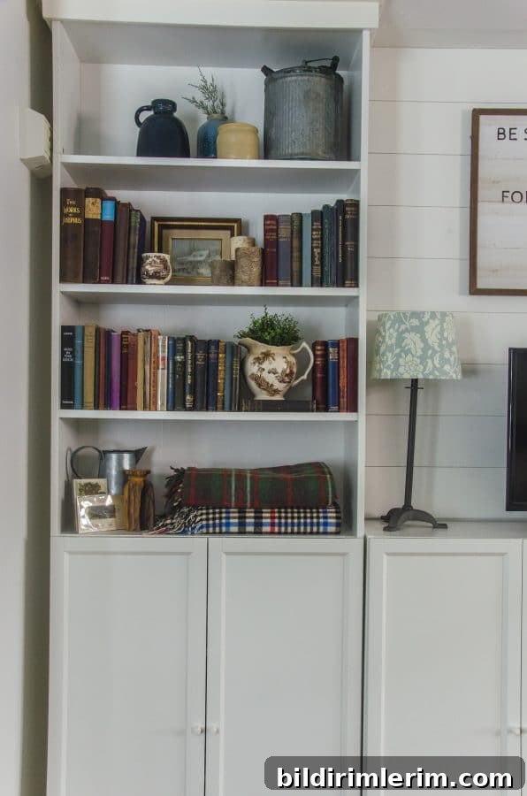 Cottagecore Winter Room Ideas for Warm, Inviting Spaces 4 An Ikea Billy Bookcase decorated with the cottagecore aesthetic - vintage books, stoneware, plants, and rustic items.