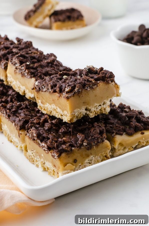 Chocolate Caramel Rice Krispy Bars cut and stacked on a cookie platter.