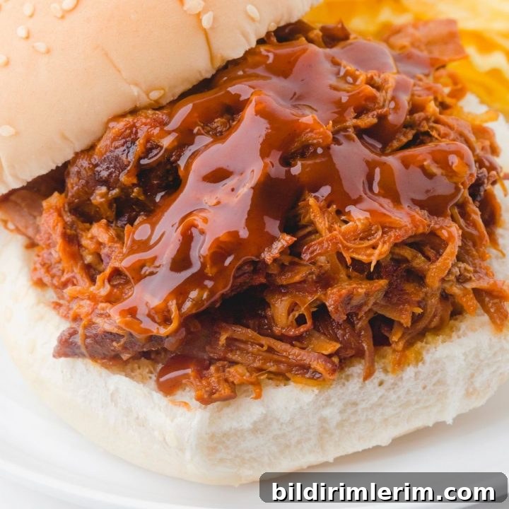 Crock Pot Pulled Pork Recipe: Tender, Juicy BBQ Flavor 4 Pulled pork crock pot recipe served on a sandwich bun. Juicy tender pork topped with barbecue sauce.