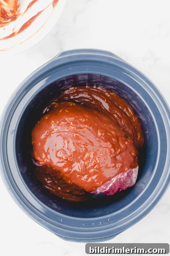 Crock Pot Pulled Pork Recipe: Tender, Juicy BBQ Flavor 6 Sauce poured on top of a pork roast in a crock pot for this easy pulled pork crock pot recipe