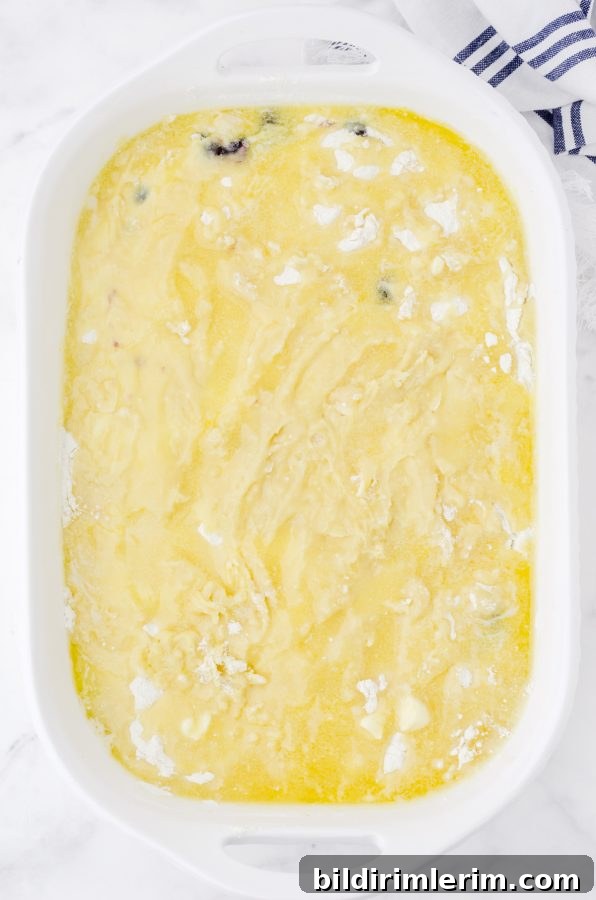 A white 9 x 13 baking dish with blueberry dump cake ready to go into the oven.