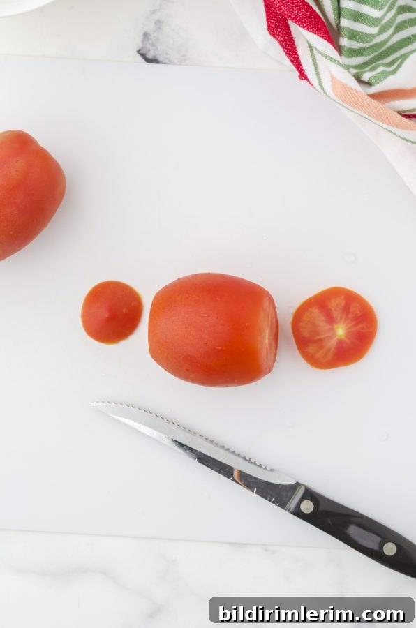 The top and bottom of a tomato cut off in preparation for deseeding a tomato
