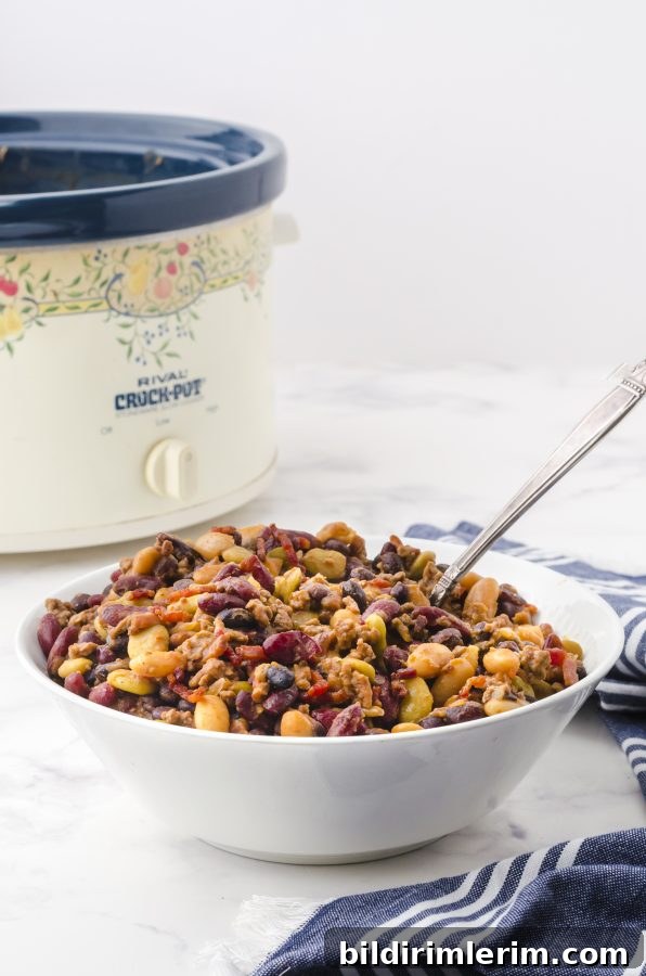 A serving bowl full of crock pot baked beans.