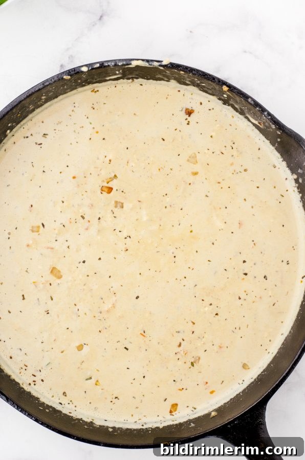 Creamy sauce for chicken florentine in a cast iron skillet.