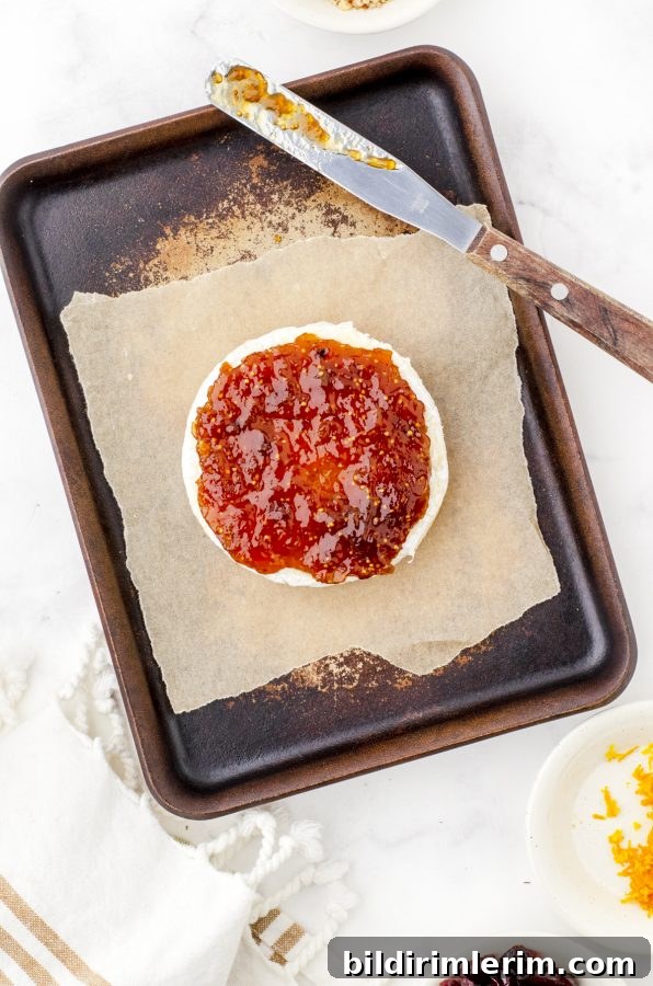 round of brie with fig jam spread on the top of it