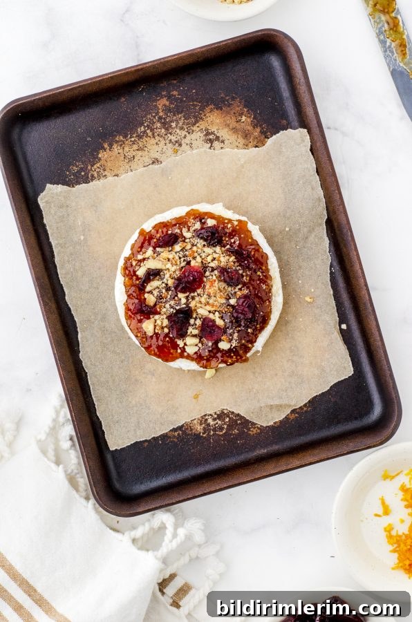round of brie with fig jam, nuts and cranberries