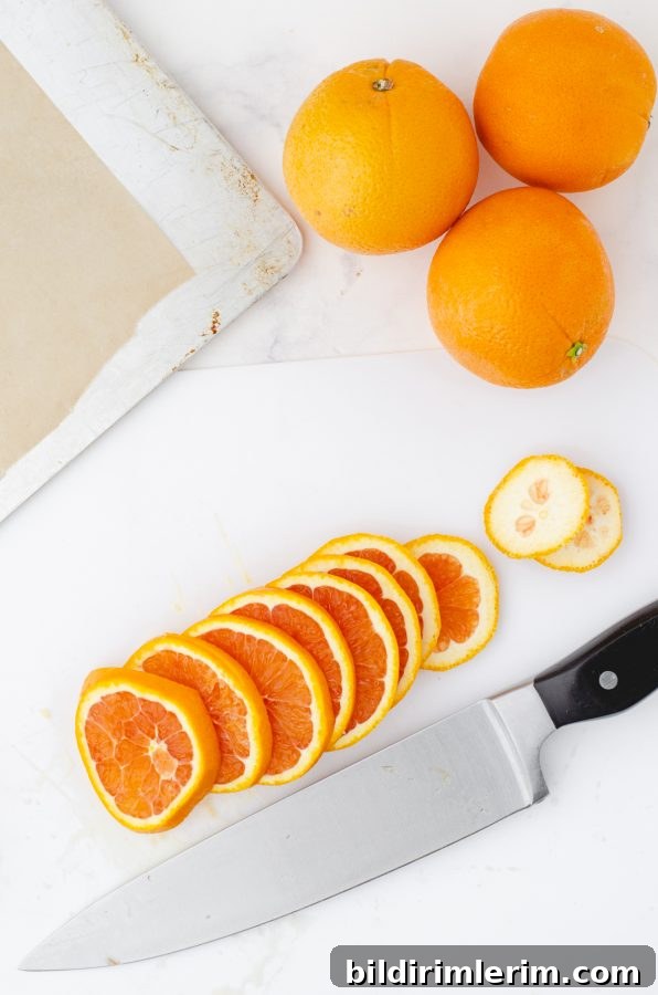 Thin slices of oranges on a cutting board by a knife that will be used to make dried orange slices