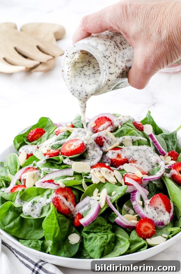 Strawberry poppyseed salad in a white bowl.