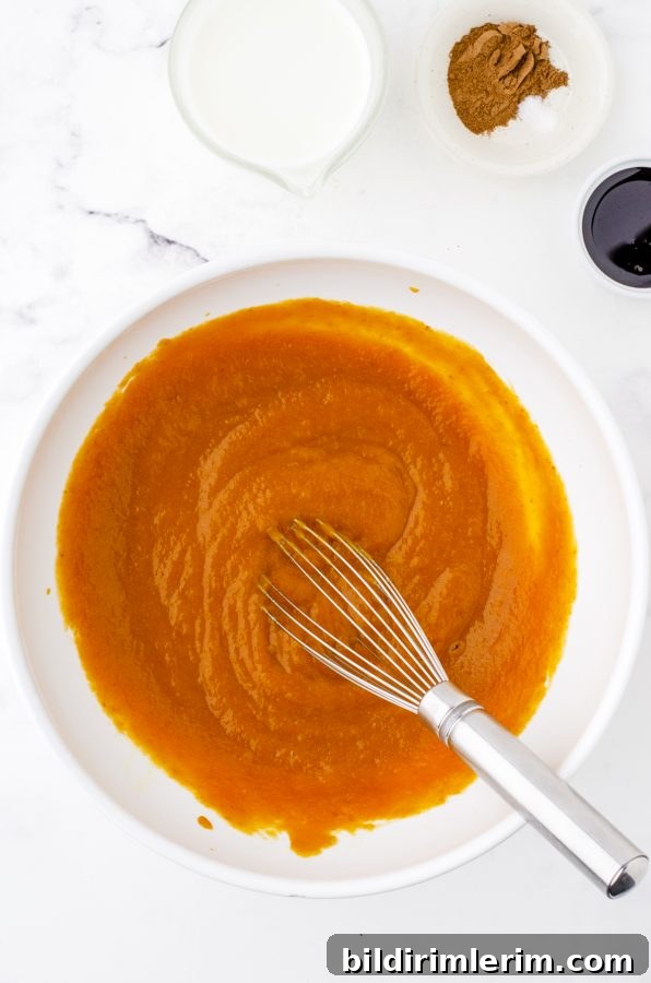 Pumpkin pie filling being whisked in a bowl