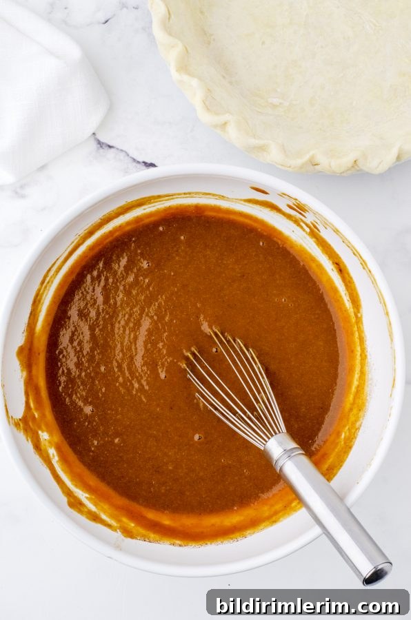 Old-fashioned pumpkin pie filling being whisked in a bowl